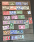 A collection of various commemorative postage stamps featuring Queen Elizabeth, arranged in a row, showcasing different colors and designs.
