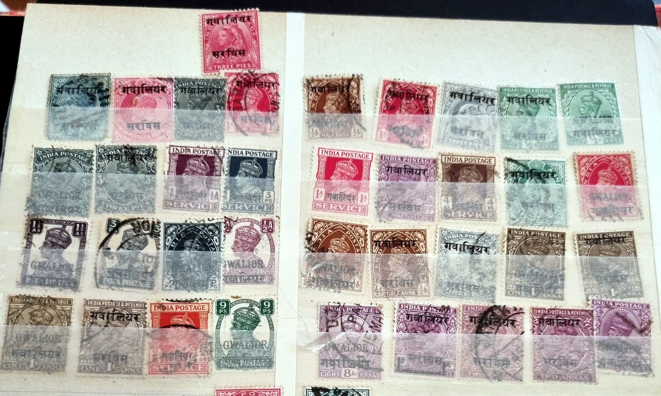 A collection of various Indian postage stamps displayed in a row, showcasing different colors and designs.