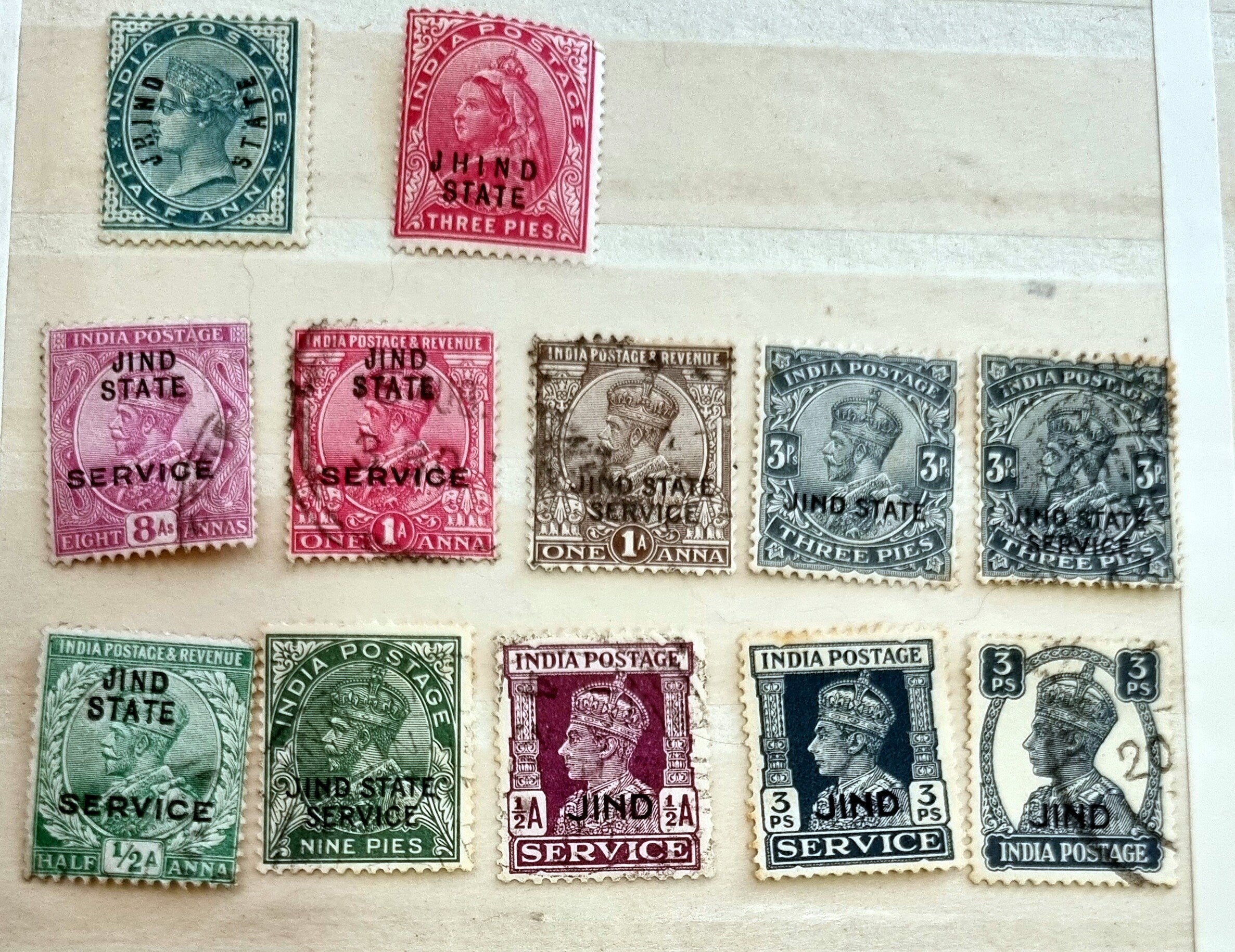 A collection of various Indian postage stamps displayed in a row, showcasing different colors and designs.