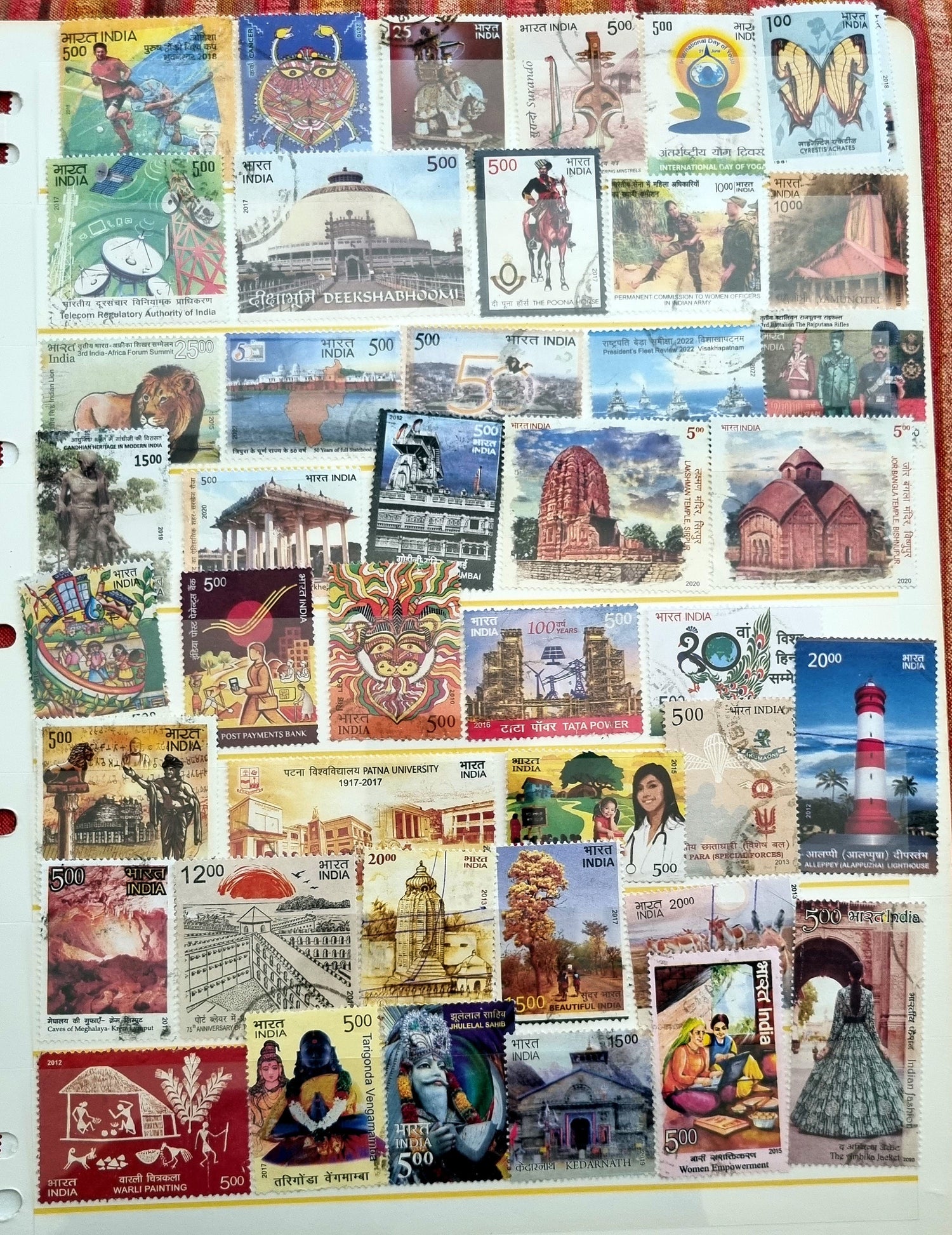 A collection of various Indian postage stamps displayed in a fanned out arrangement, showcasing different colors and designs with various images, including historical figures and national symbols.