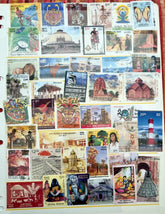 A collection of various Indian postage stamps displayed in a fanned out arrangement, showcasing different colors and designs with various images, including historical figures and national symbols.