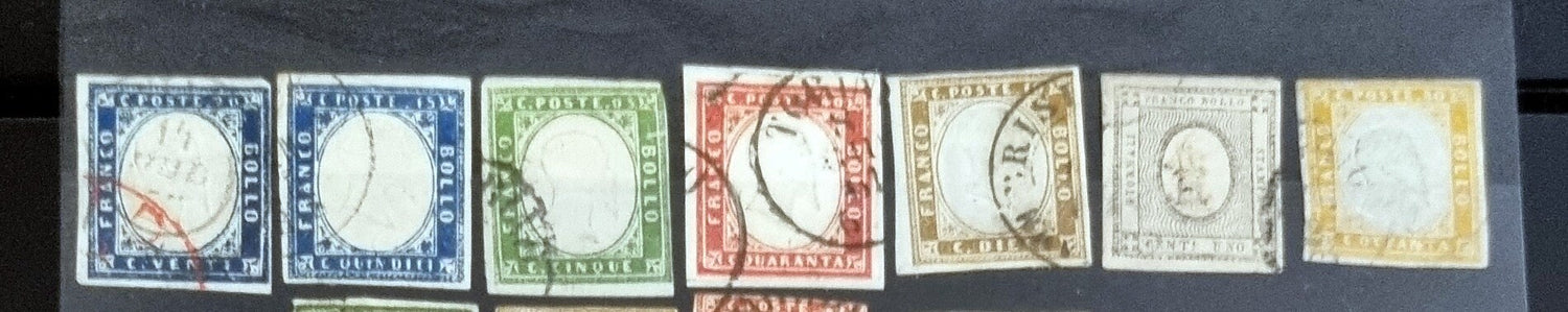 A collection of three vintage Sardinia stamps with a portrait of King Victor Emmanuel II, displayed against a blurred background.