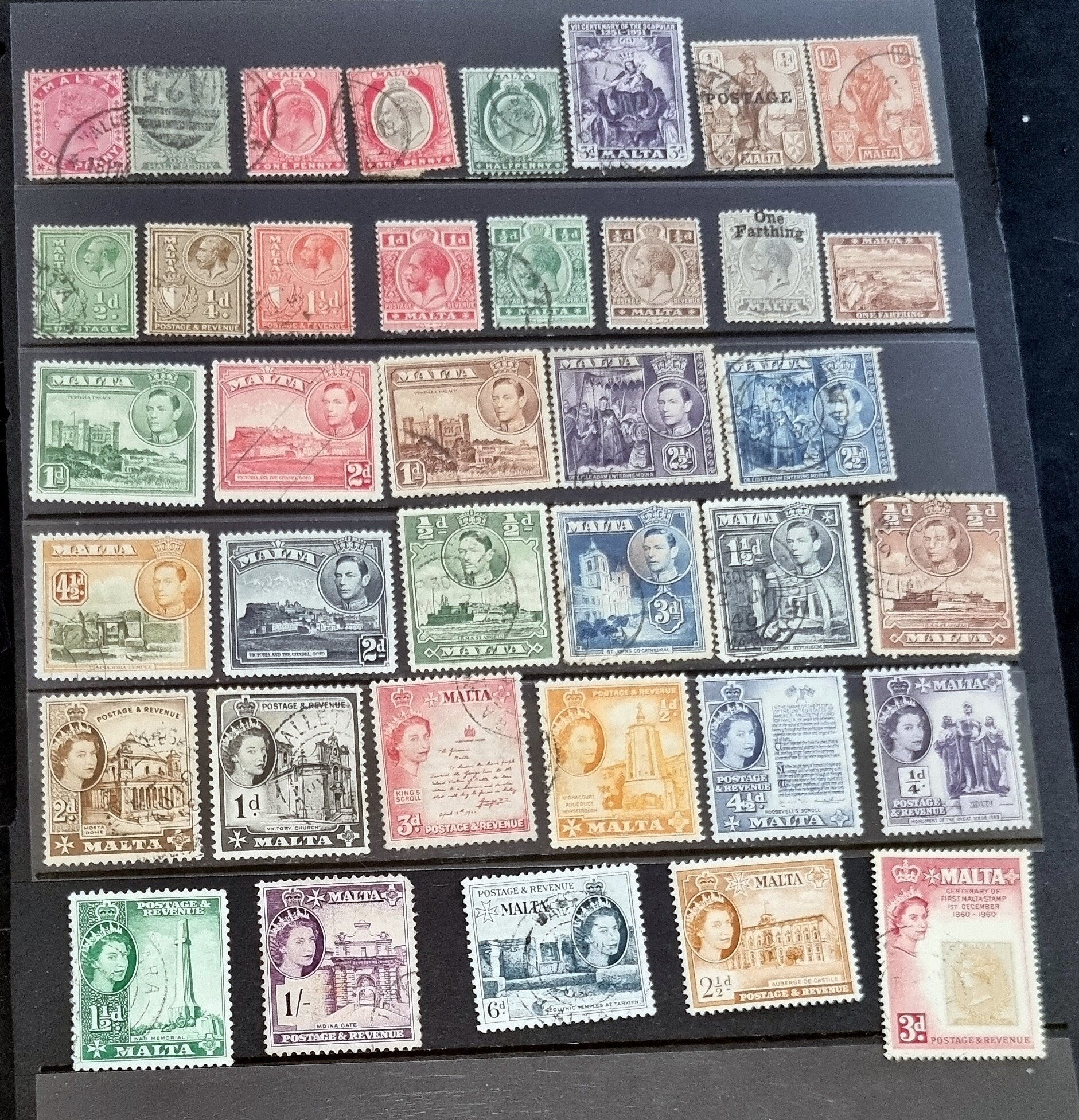A collection of vintage postage stamps from Malta featuring various designs and colors, arranged in no specific order on a surface.