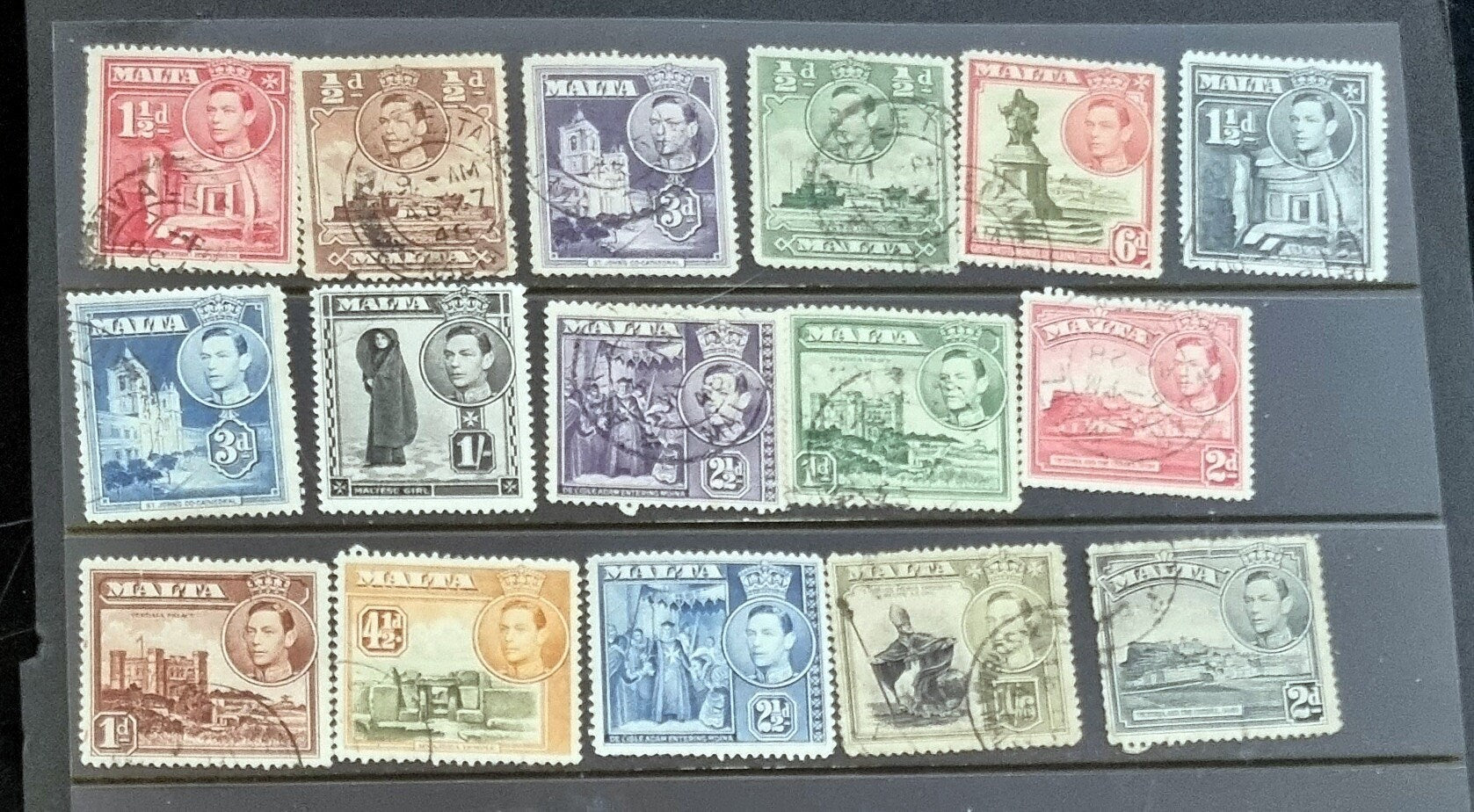 A collection of vintage postage stamps from Malta featuring various designs and colors, arranged in no specific order on a surface.