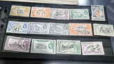 A collection of vintage British Nigeria stamps displayed on a surface, featuring various colors and motifs related to different eras in Nigerian history.
