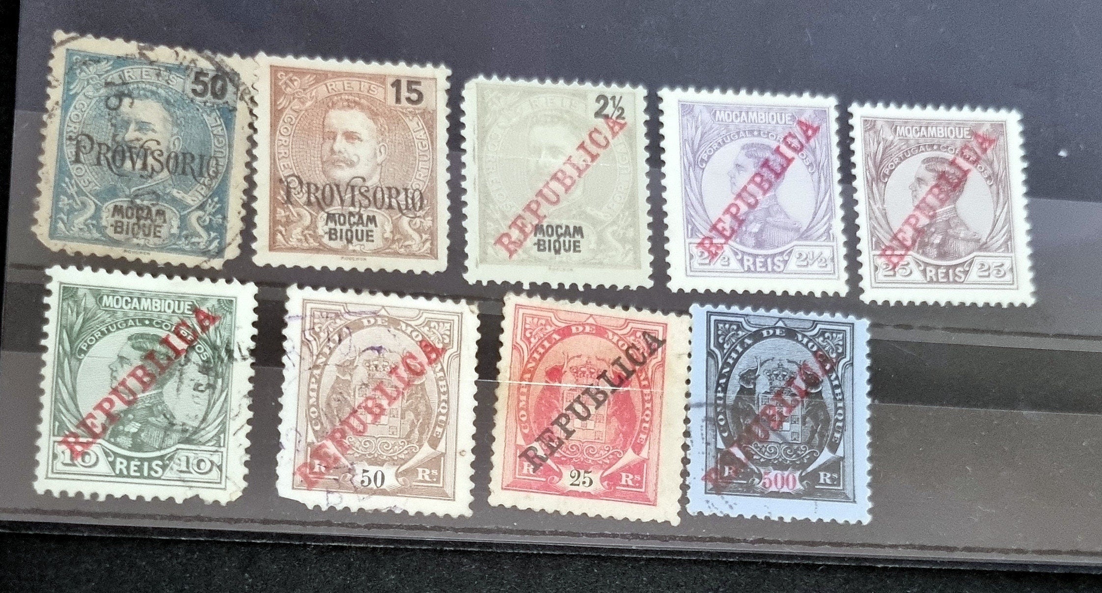 A collection of vintage Portuguese and colonies stamps displayed fanned out on a surface, featuring various designs and denominations.