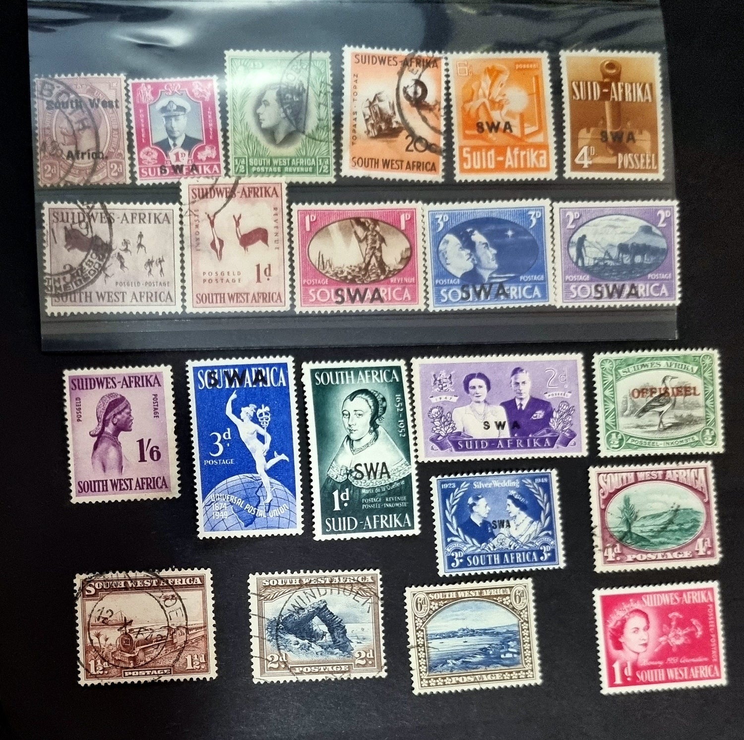 A collection of various vintage South West Africa stamps laid out on a surface.