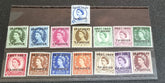 A collection of various vintage Tangier postage stamps displayed on a surface, with different colors and designs, including portraits of a king and a queen.