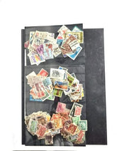 A collection of various postage stamps arranged in a pile, featuring different colors and designs, with no duplicates.