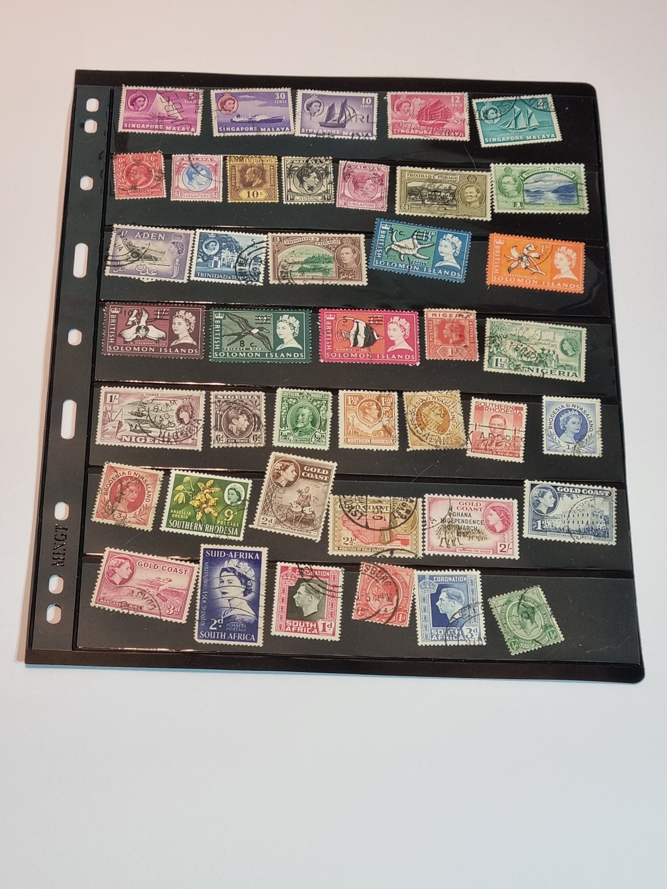 A collection of various postage stamps arranged in a pile, featuring different colors and designs, with no duplicates.
