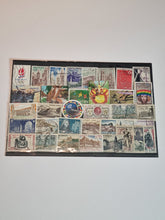 A collection of various postage stamps arranged in a pile, featuring different colors and designs, with no duplicates.