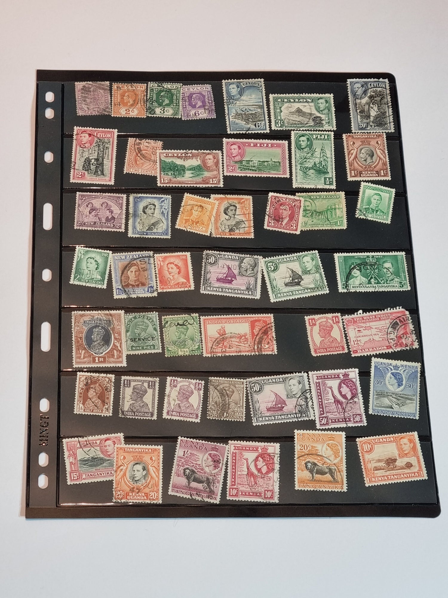 A collection of various postage stamps arranged in a pile, featuring different colors and designs, with no duplicates.