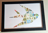 Framed artwork of a bird shape made from various stamps on a white background