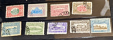 A collection of vintage postage stamps displayed on a black surface. The stamps feature various colors including red, blue, green, purple, and brown, with some showing postmarks and others displaying architectural illustrations.