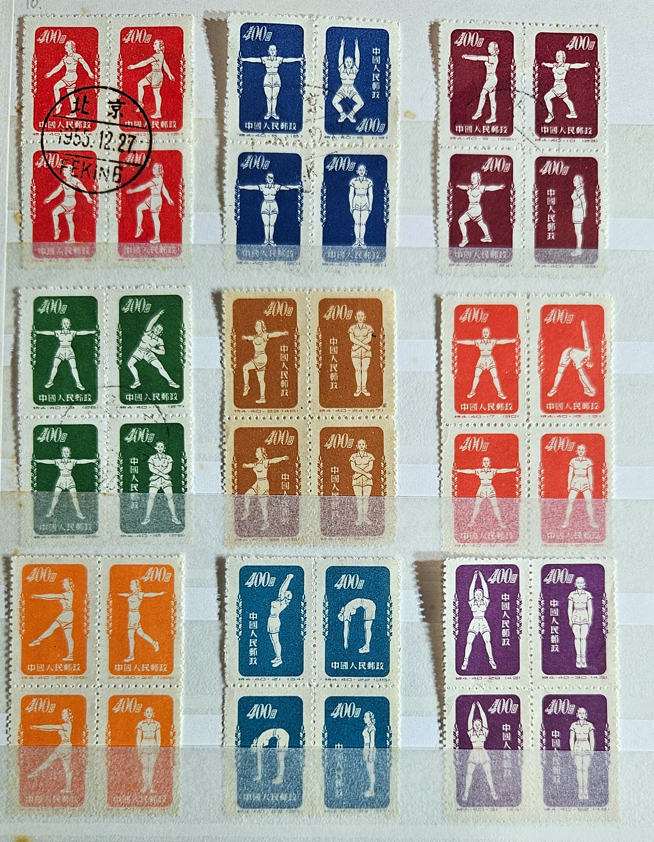 A collection of vintage Chinese postage stamps from the early 1950s depicting gymnasts and various symbols, cancellation marks visible.