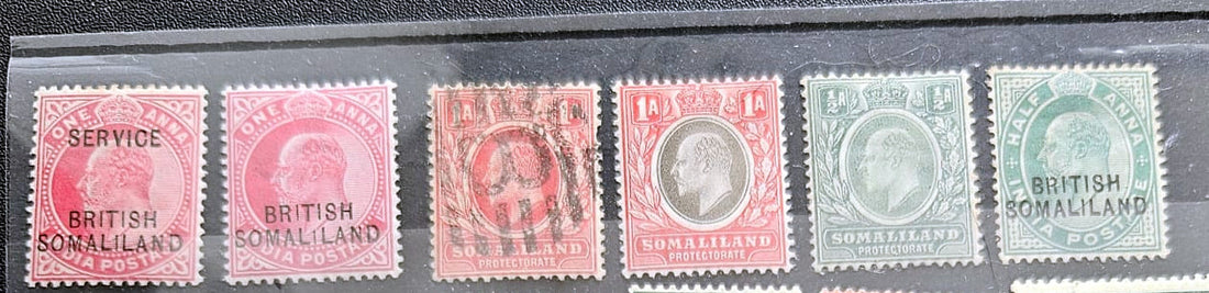 Six vintage British Somaliland postage stamps displayed side by side in a black case. The stamps show different denominations and colors including pink, red, orange, green, and blue, with some cancellation marks.