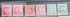Six vintage British Somaliland postage stamps displayed side by side in a black case. The stamps show different denominations and colors including pink, red, orange, green, and blue, with some cancellation marks.