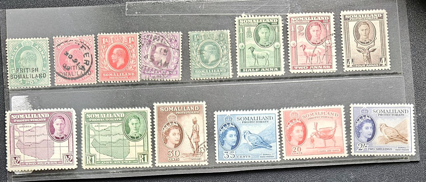A collection of vintage Somaliland postage stamps displayed on a black background, arranged in two rows. The stamps feature various colors including green, red, pink, blue, and brown, with different denominations and designs.