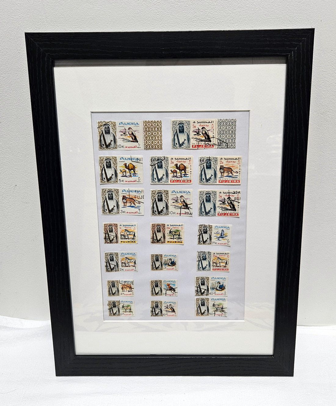Framed collection of Fujairah vintage stamps with black frame