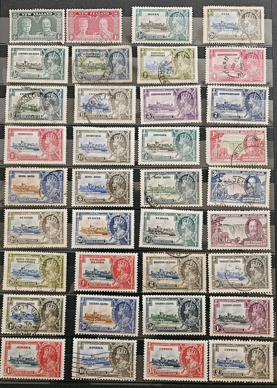 A collection of vintage postage stamps arranged in a grid on a dark background. The stamps feature various colors including red, blue, green, purple, and brown, with some showing postmarks and cancellations.