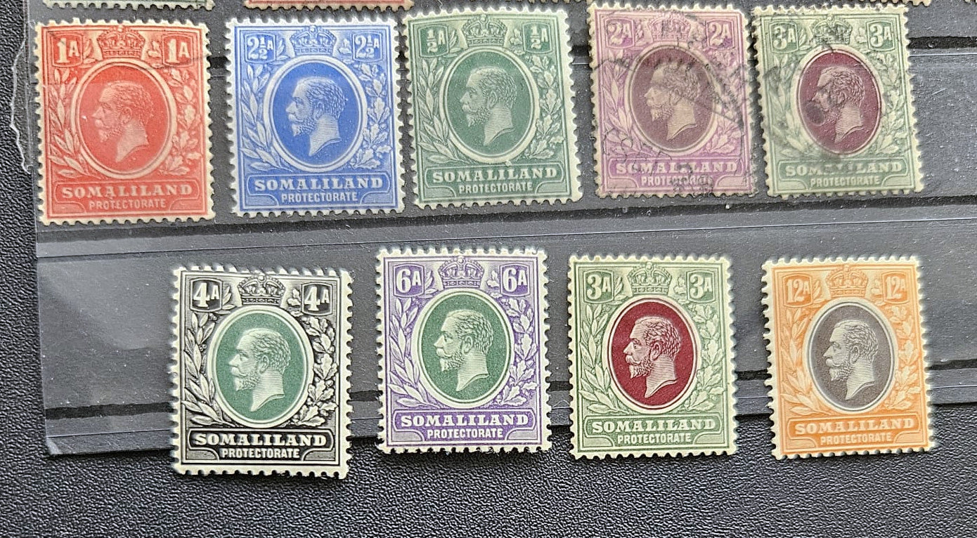 A set of ten vintage Somaliland postage stamps from the British Empire, featuring various colors including red, blue, green, purple, orange, and brown, arranged on a black textured surface.
