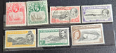 A collection of British Commonwealth Ascension vintage stamps displayed on a surface, featuring various colors and images representing different historical periods.