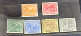 A collection of vintage St Kitts and Nevis stamps displayed against a dark background. The stamps vary in color and design, featuring various denominations and historical figures.