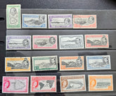 A set of vintage British Ascension Island postage stamps arranged in rows on a black display card. The stamps feature various colors and denominations, including green, blue, purple, orange, and pink, with Queen Elizabeth II&