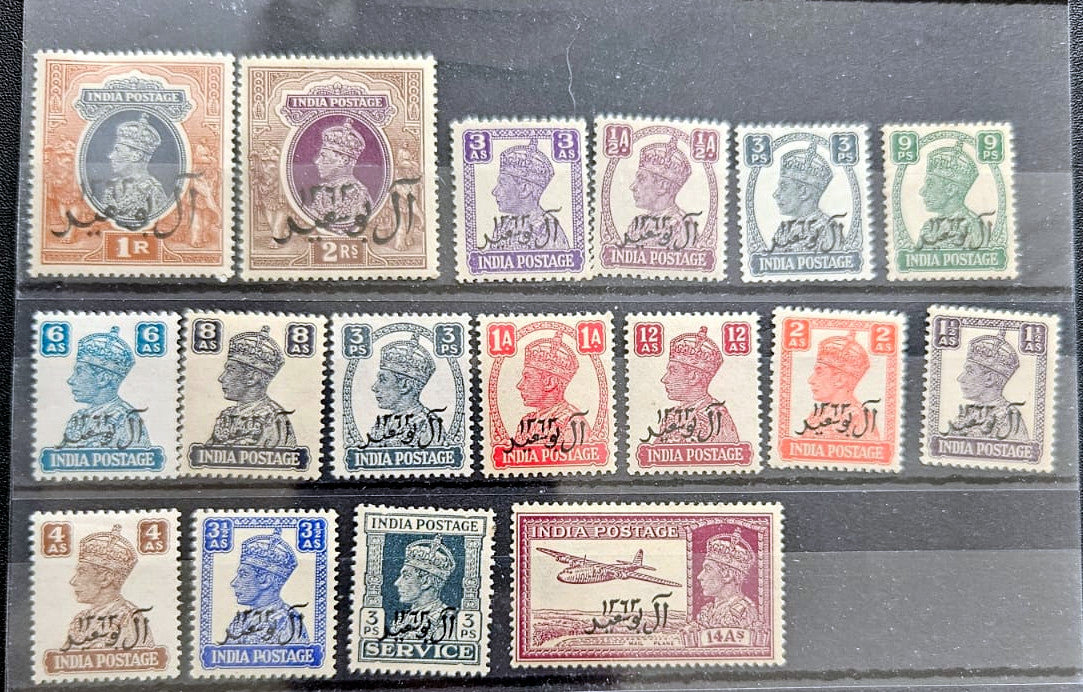 A set of vintage Indian postage stamps arranged in three rows on a dark background. The stamps feature the profile of King George V and various denominations, printed in different colors including brown, purple, blue, red, green, and blue-gray.