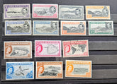 A set of vintage British Ascension  stamps in various colors and denominations, arranged in rows on a dark wooden surface.