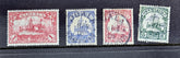 A set of vintage German colonies postage stamps, featuring various designs and colors, predominantly in shades of red and green.