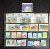 A collection of various Kazakhstan postage stamps displayed in a row, showcasing different designs and colors.