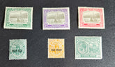 A collection of vintage St Kitts and Nevis stamps displayed against a dark background. The stamps vary in color and design, featuring various denominations and historical figures.