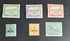 A collection of vintage St Kitts and Nevis stamps displayed against a dark background. The stamps vary in color and design, featuring various denominations and historical figures.