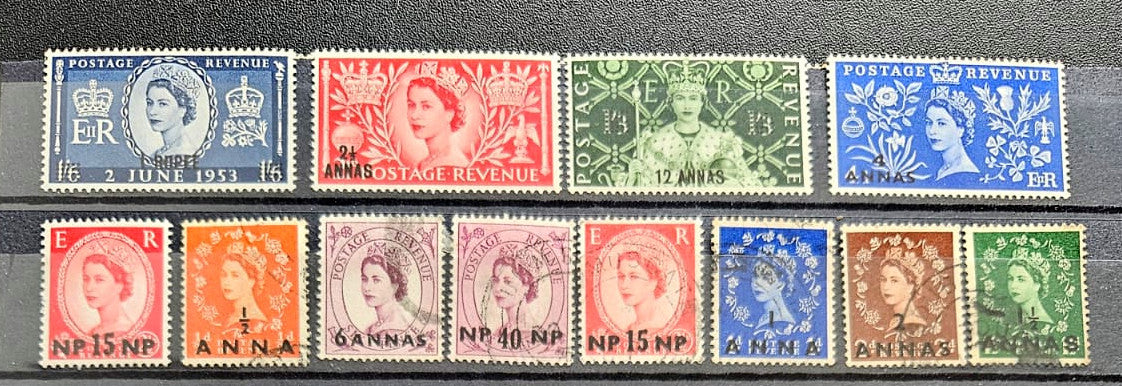 A set of vintage Queen Elizabeth II postage stamps from the United Kingdom, arranged in two rows on a dark textured background. 