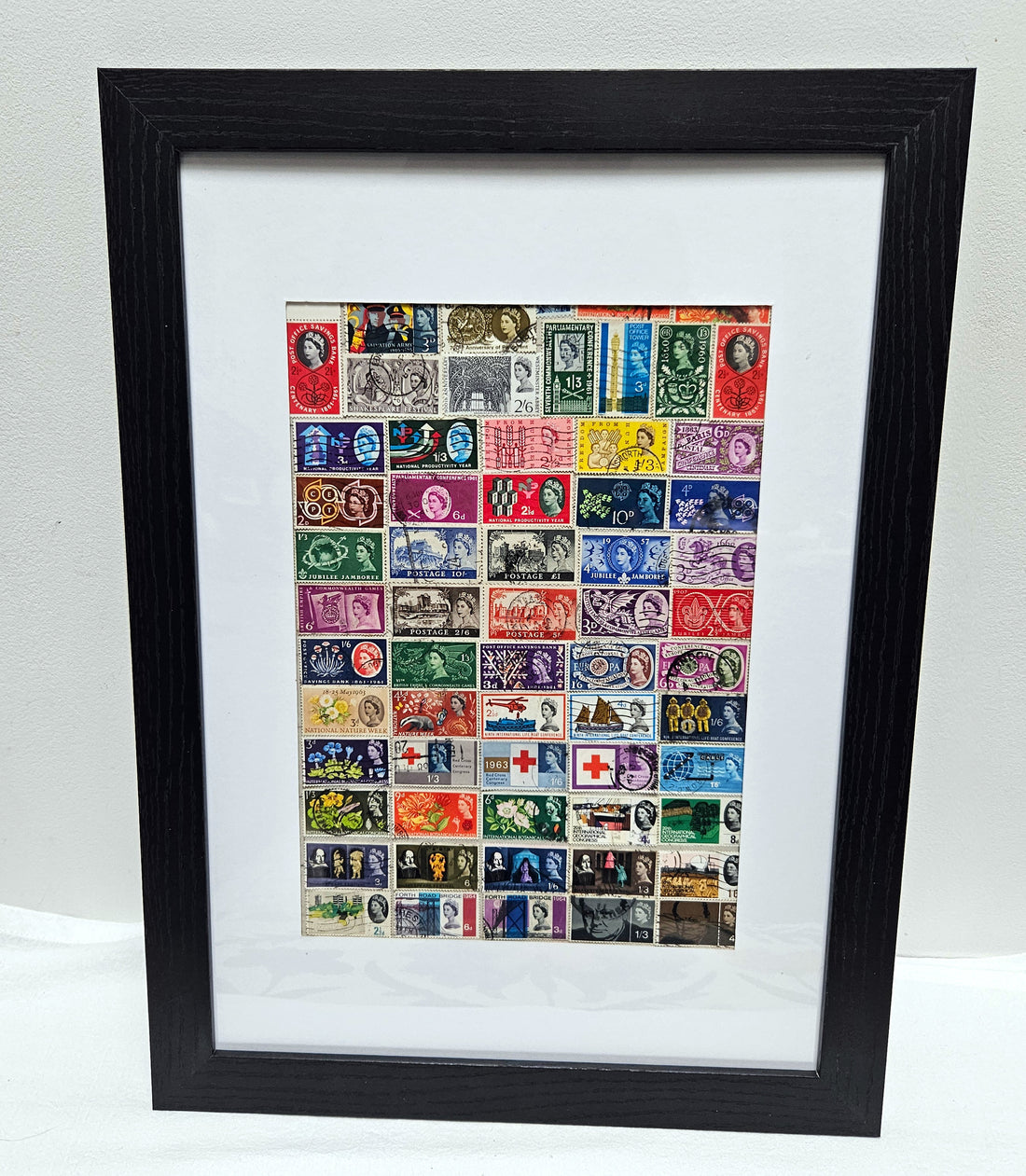 Framed collection of Queen Elizabeth 1953-1966 vintage stamps on a white background