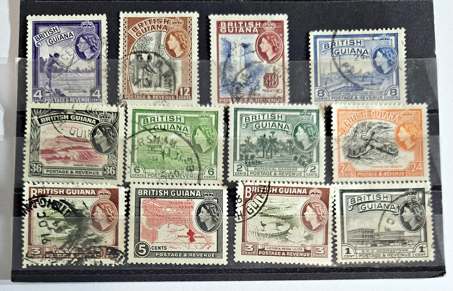 A collection of vintage British Guyana stamps from the reign of King George V, featuring various designs including portraits and imagery of local flora and fauna.
