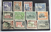 A collection of vintage British Guyana stamps from the reign of King George V, featuring various designs including portraits and imagery of local flora and fauna.