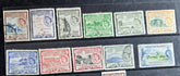 A collection of vintage St Kitts and Nevis stamps displayed against a dark background. The stamps vary in color and design, featuring various denominations and historical figures.