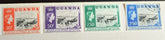 A collection of British Commonwealth Uganda stamps from various monarchs displayed on a surface.