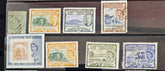 A collection of vintage St Kitts and Nevis stamps displayed against a dark background. The stamps vary in color and design, featuring various denominations and historical figures.