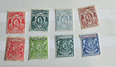 A collection of British Commonwealth Uganda stamps from various monarchs displayed on a surface.