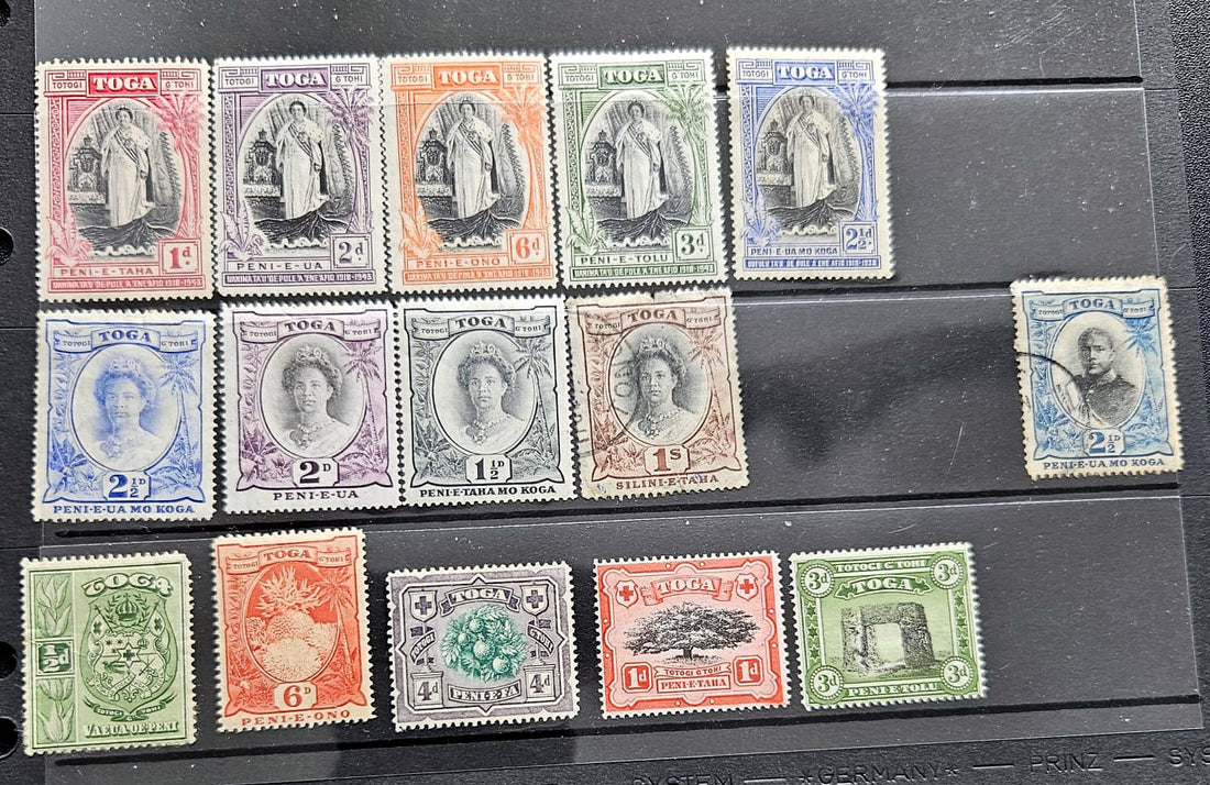 A set of vintage Togoa postage stamps arranged on a black plastic album page, showing multiple colors and denominations.