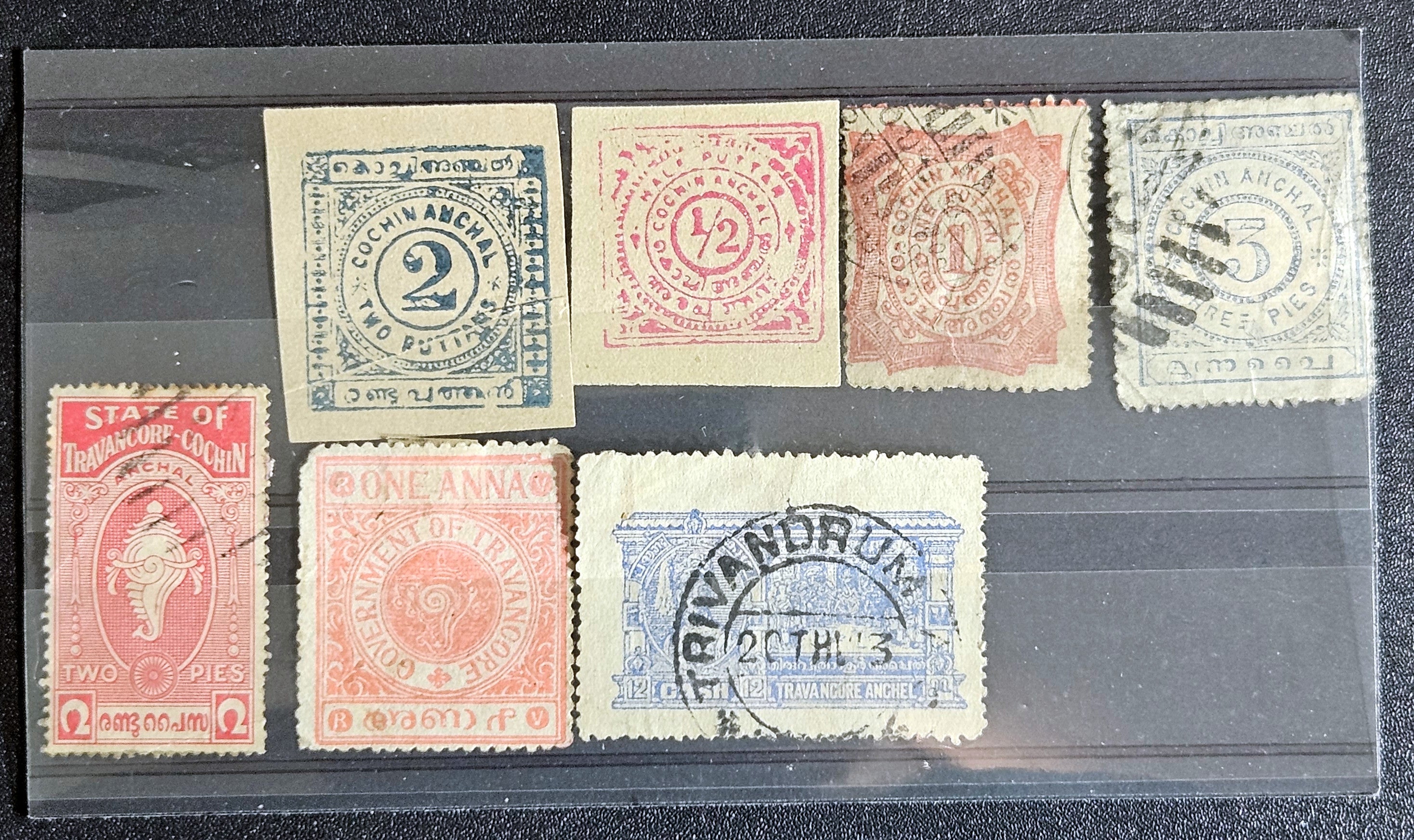 A collection of various Indian postage stamps displayed in a row, showcasing different colors and designs.