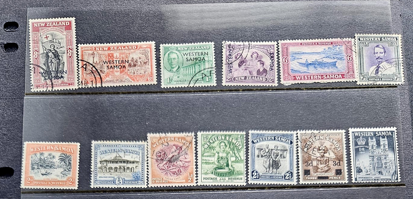A set of vintage Western Samoa postage stamps displayed on a black binder page, showing multiple colors and designs from the late 19th to early 20th century.