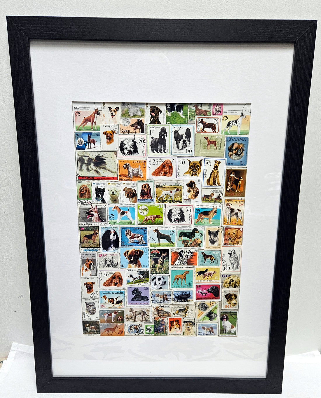 Framed collage of various dog stamps on a white background