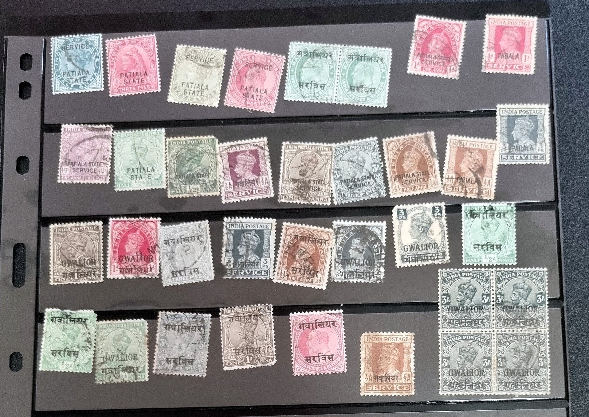A collection of various Indian postage stamps displayed in a row, showcasing different colors and designs.