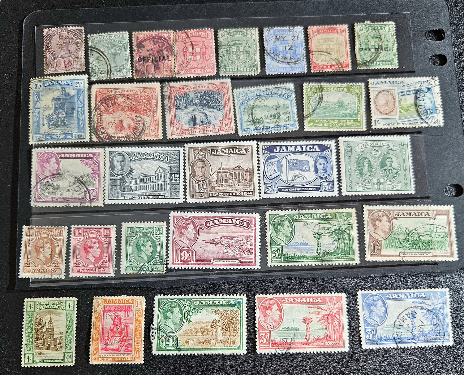 A collection of vintage Jamaica stamps from various reigns of British monarchs, displayed on a black background.