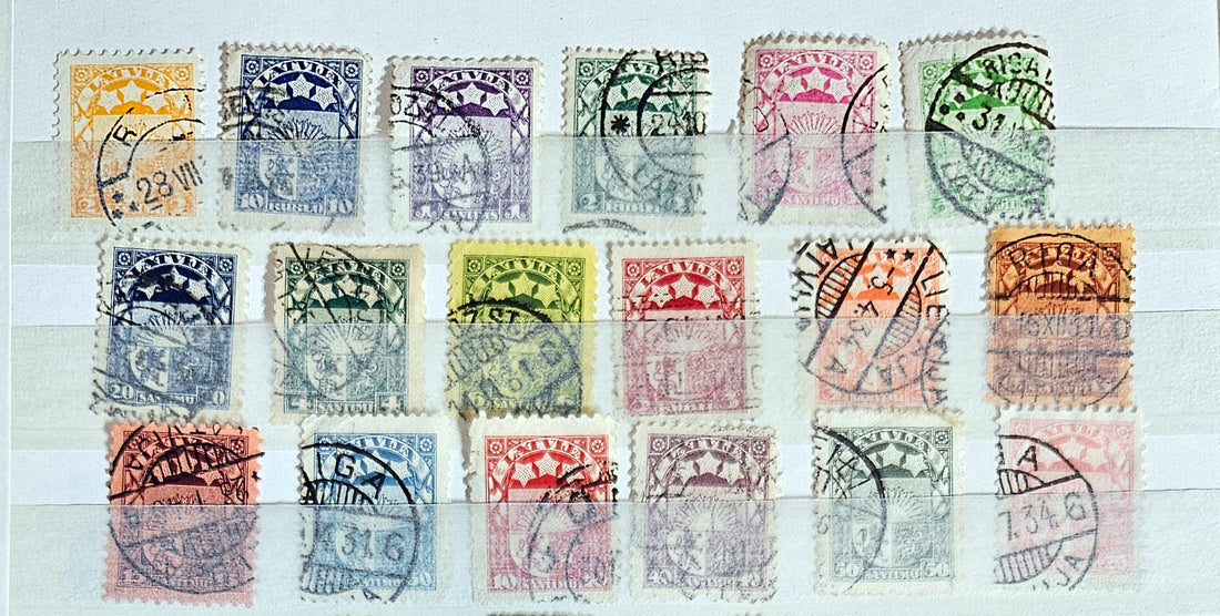 A collection of various Latvian stamps arranged in rows, showcasing different designs and cancellation marks.