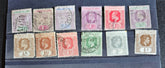 A collection of vintage Leeward Islands stamps featuring various monarchs from Queen Victoria to Queen Elizabeth II, displayed on a flat surface.